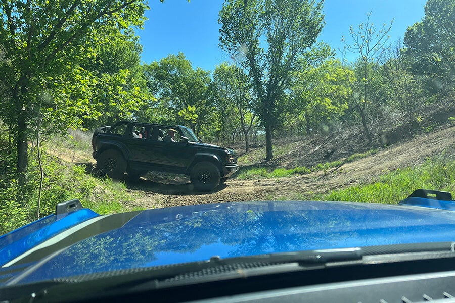 A black and blue off-road vehicle driving while off-roading