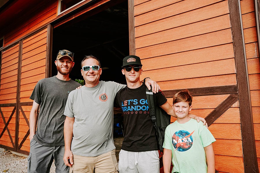 A group of four men and boys posing for a photo