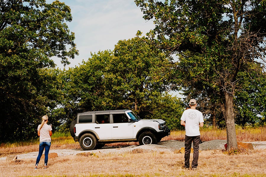 A man standing next to a white Ford Bronco