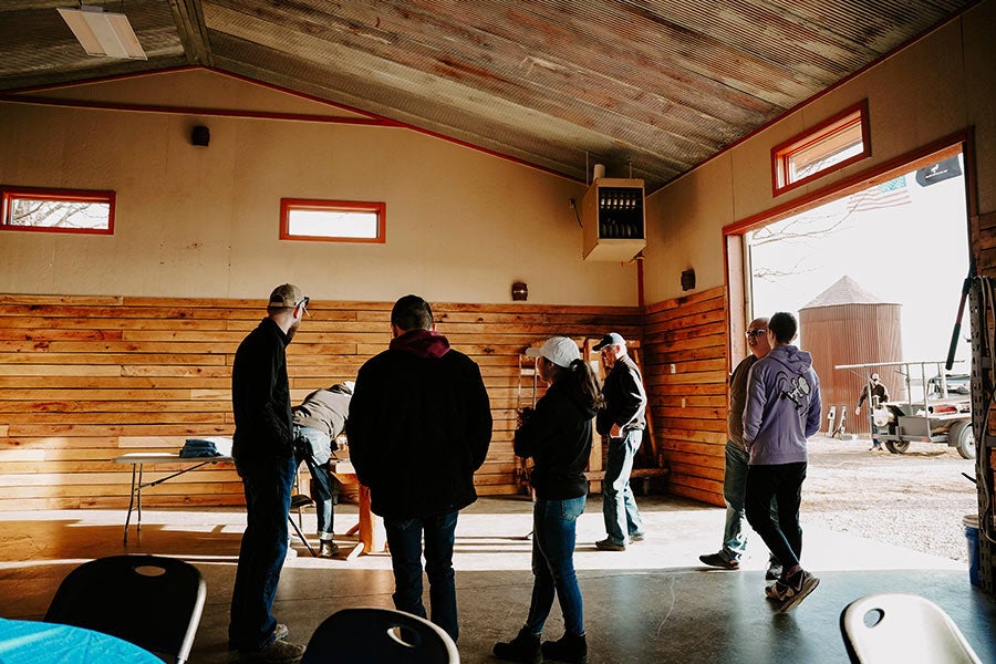 A group of people gathered inside a large barn-like building