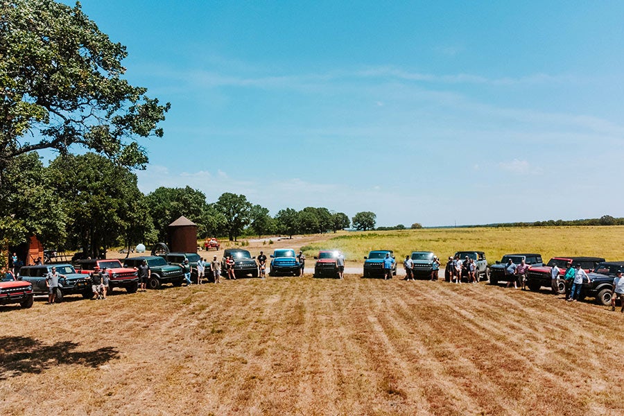 A wide shot of many off-road vehicles parked in a field
