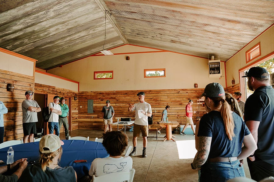 A group of people gathered around a table in a rustic building.