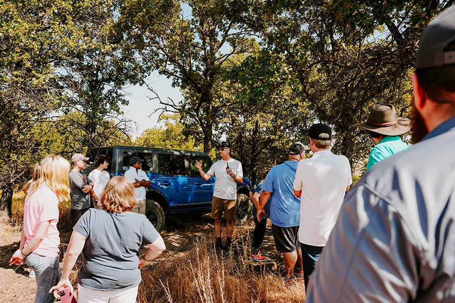 Two men posing for a photo with a Ford Bronco.