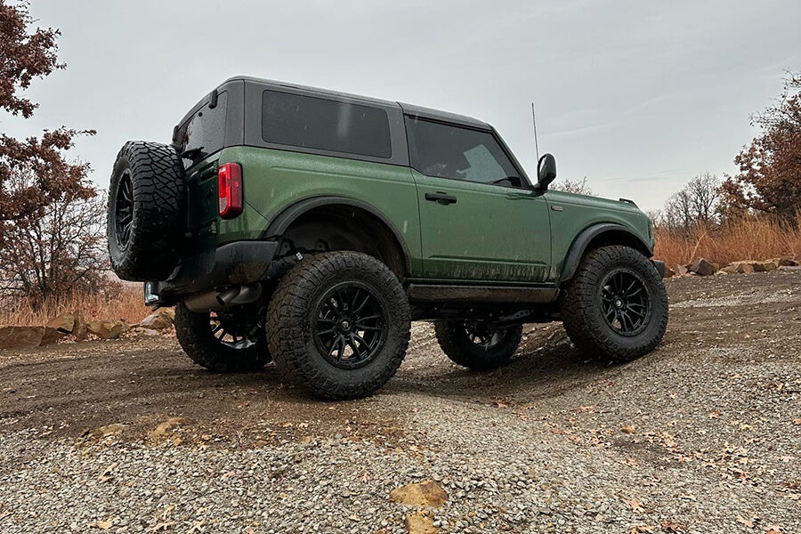 A green Ford Bronco parked on an off-road trail.
