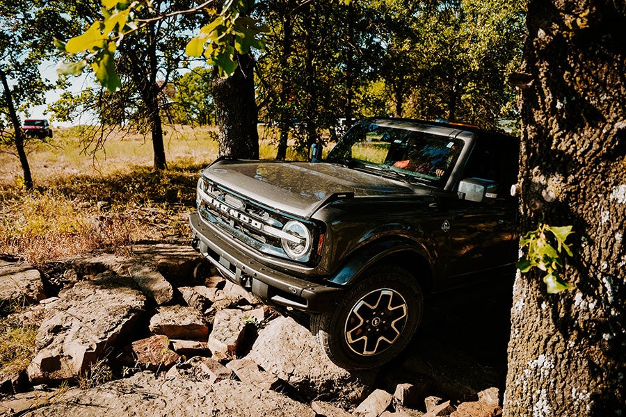 A black Ford Bronco parked on a rocky trail.
