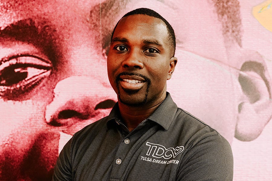 A close-up portrait of a smiling man.