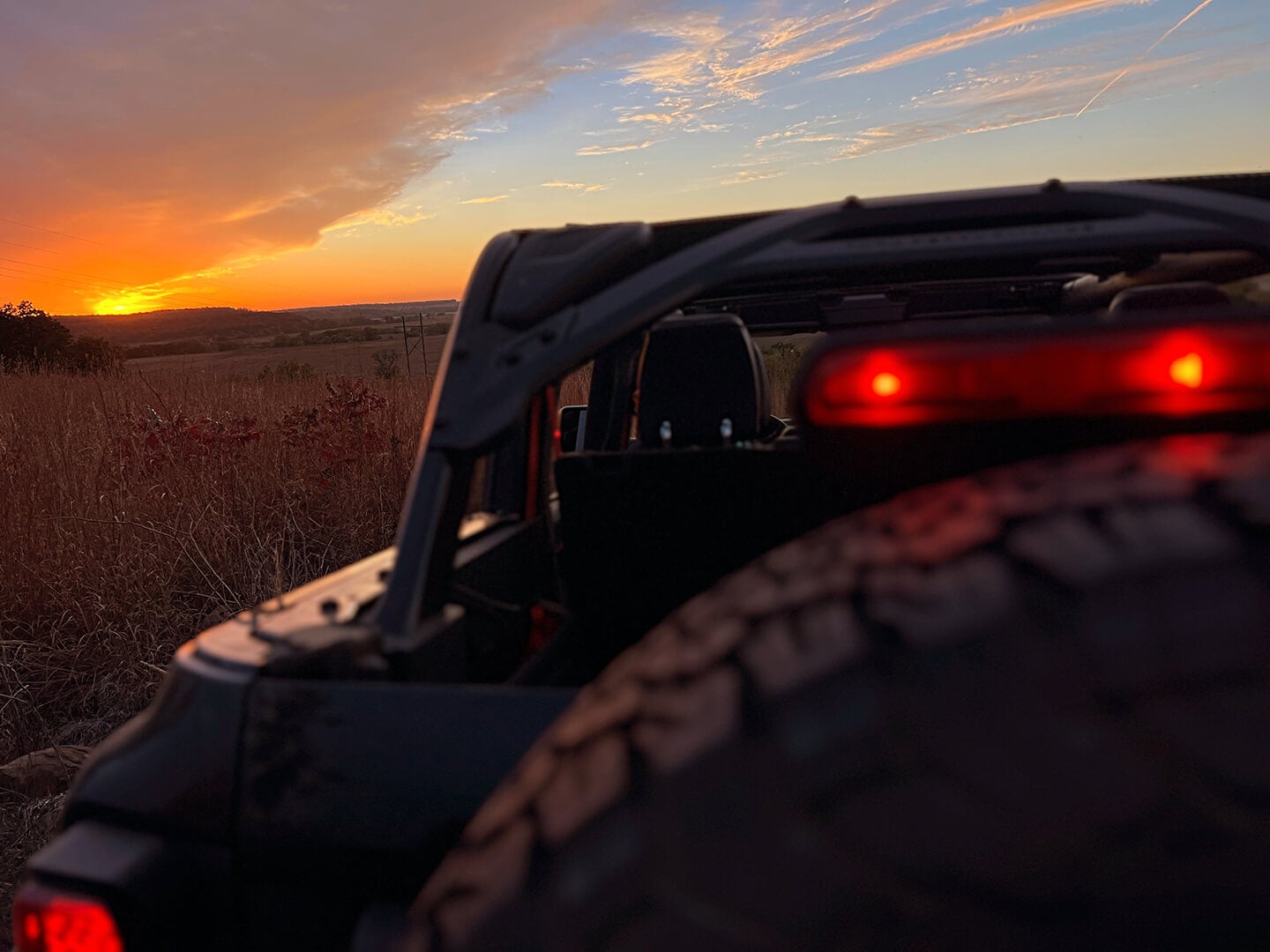 A low-angle shot of a Ford Bronco's rear grille at sunset