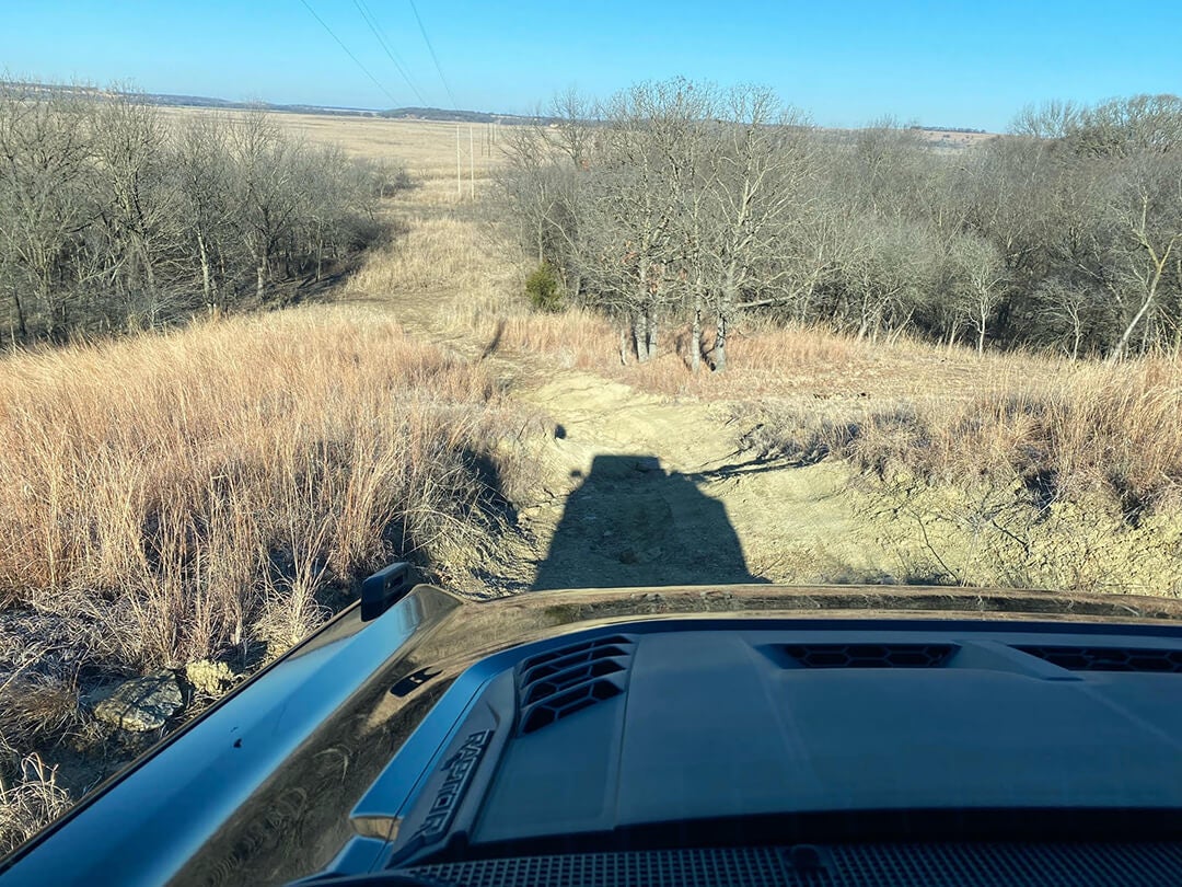 A view from the sunroof of a Ford Bronco, looking out at a hilly landscape