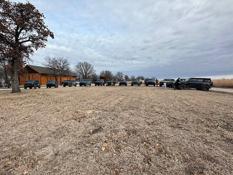 Line of SUVs parked near a wooden building outdoors