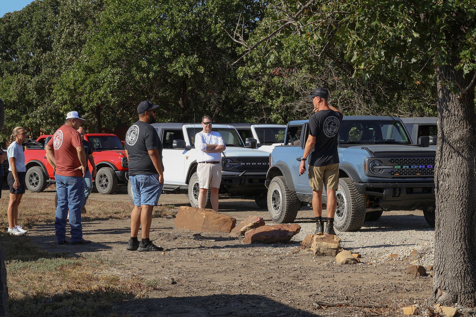 A group of people standing around a Ford Bronco.