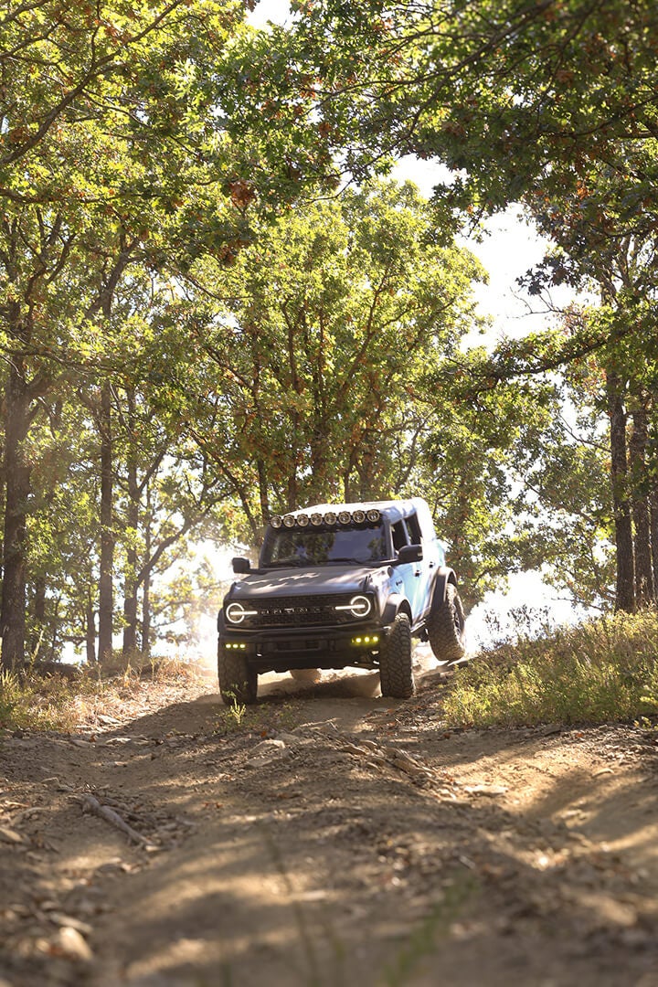 A front view of a white Ford Bronco off-roading.