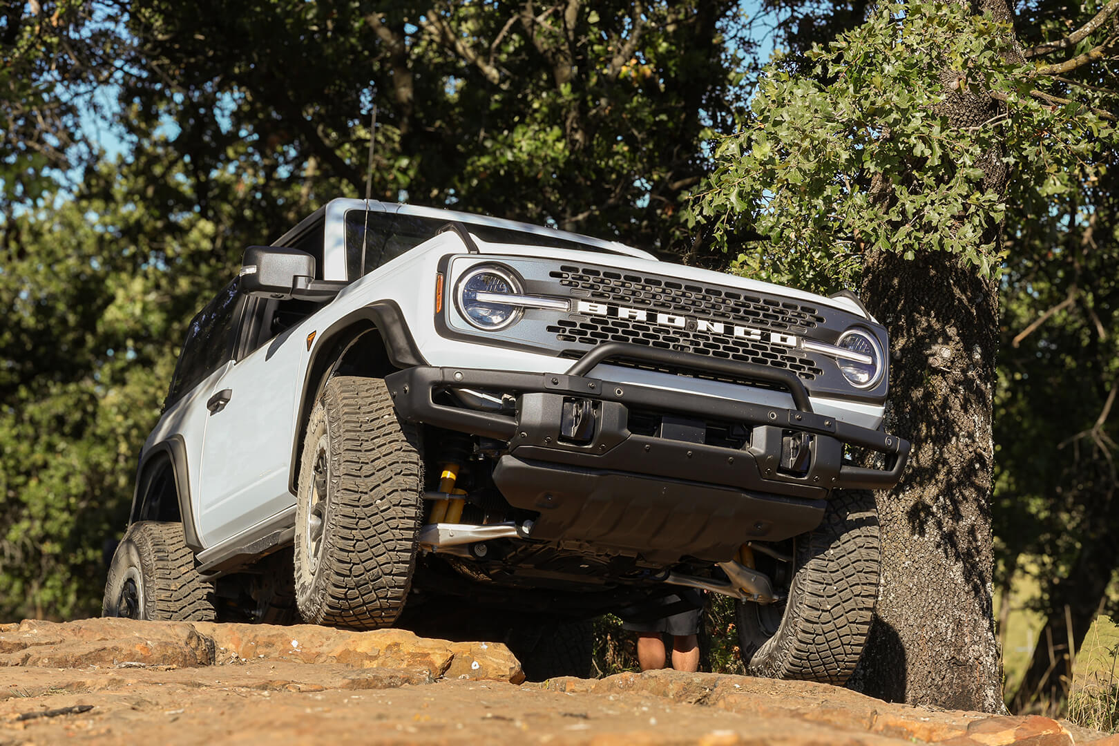A front view of a gray Ford Bronco off-roading.